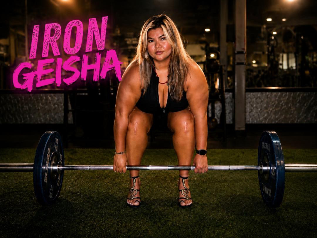 Sirena, founder of Iron Geisha, deadlifting in front of a pink Iron Geisha mural